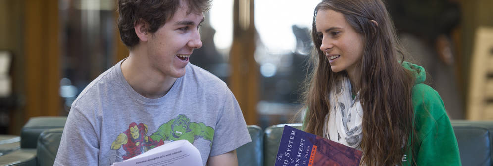 2 students having a discussion while holding open books